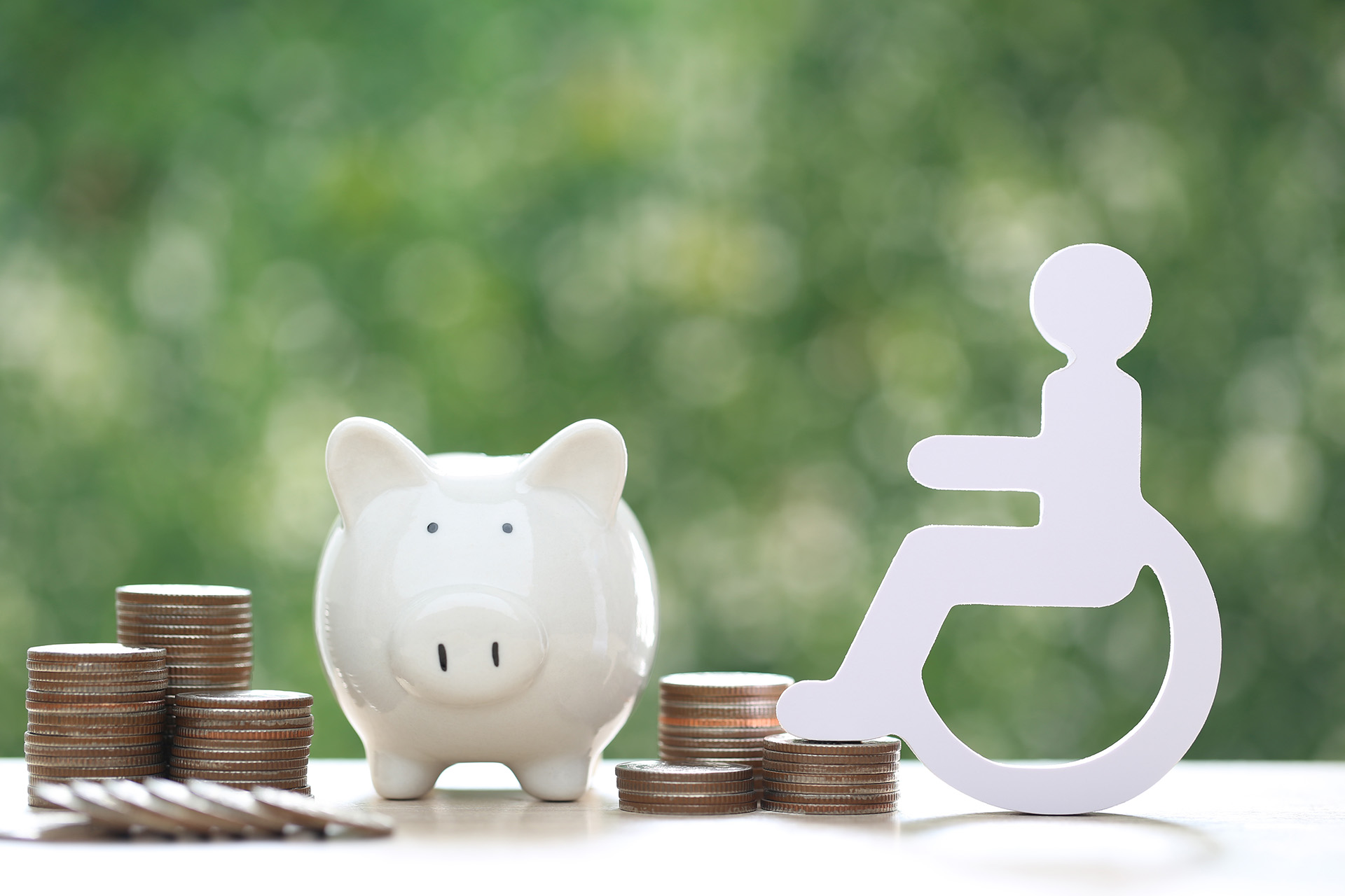 Icon of a person in a wheelchair beside a piggy bank and coins, symbolising how veterans can get disability support with a full benefits check.