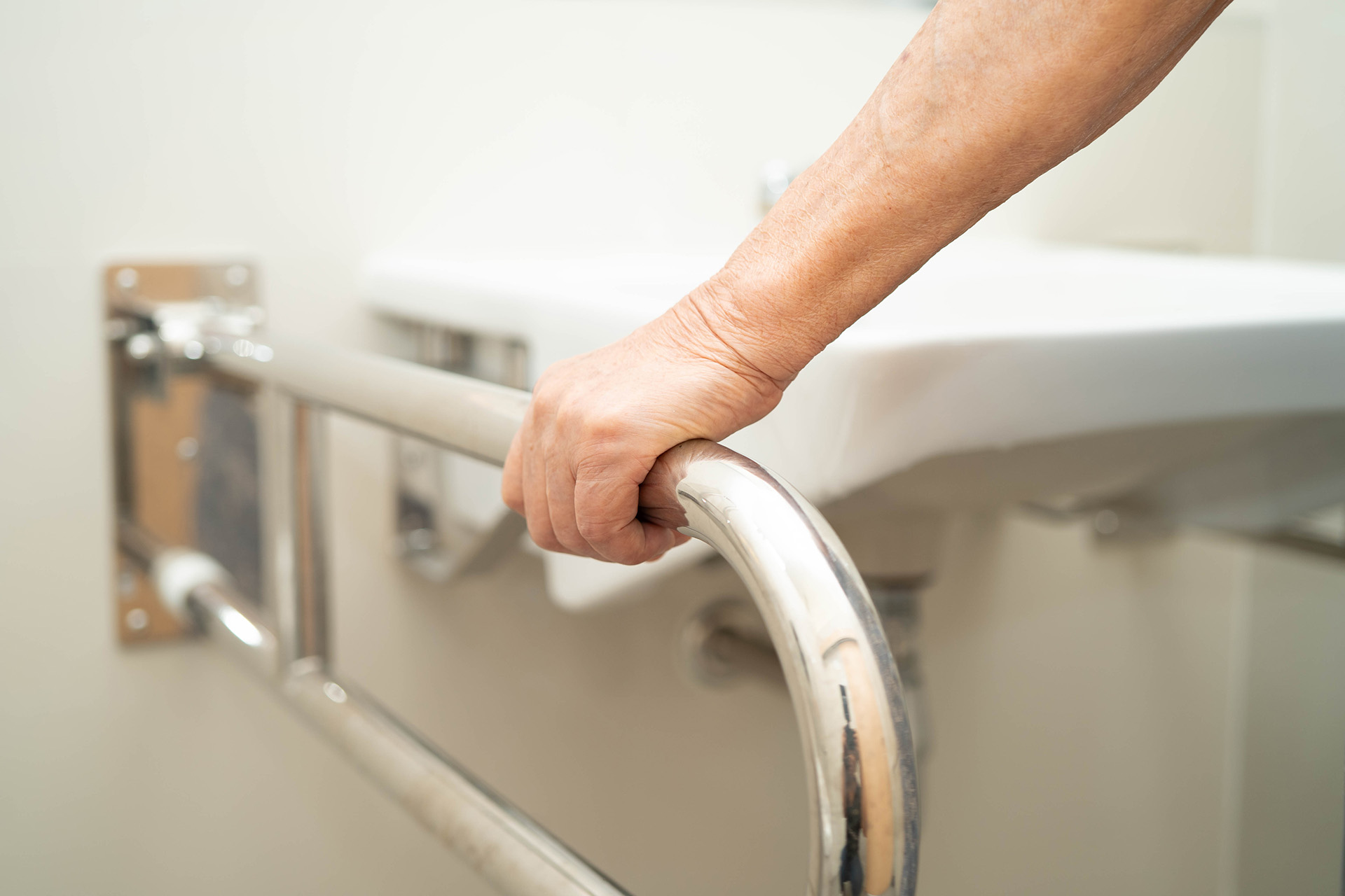 A disabled veteran holding a bathroom handrail, highlighting disability support for veterans in Scotland through home adaptations.