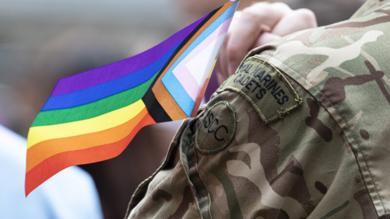 A Royal Marines Cadet with the LGBT+ flag by their arm.
