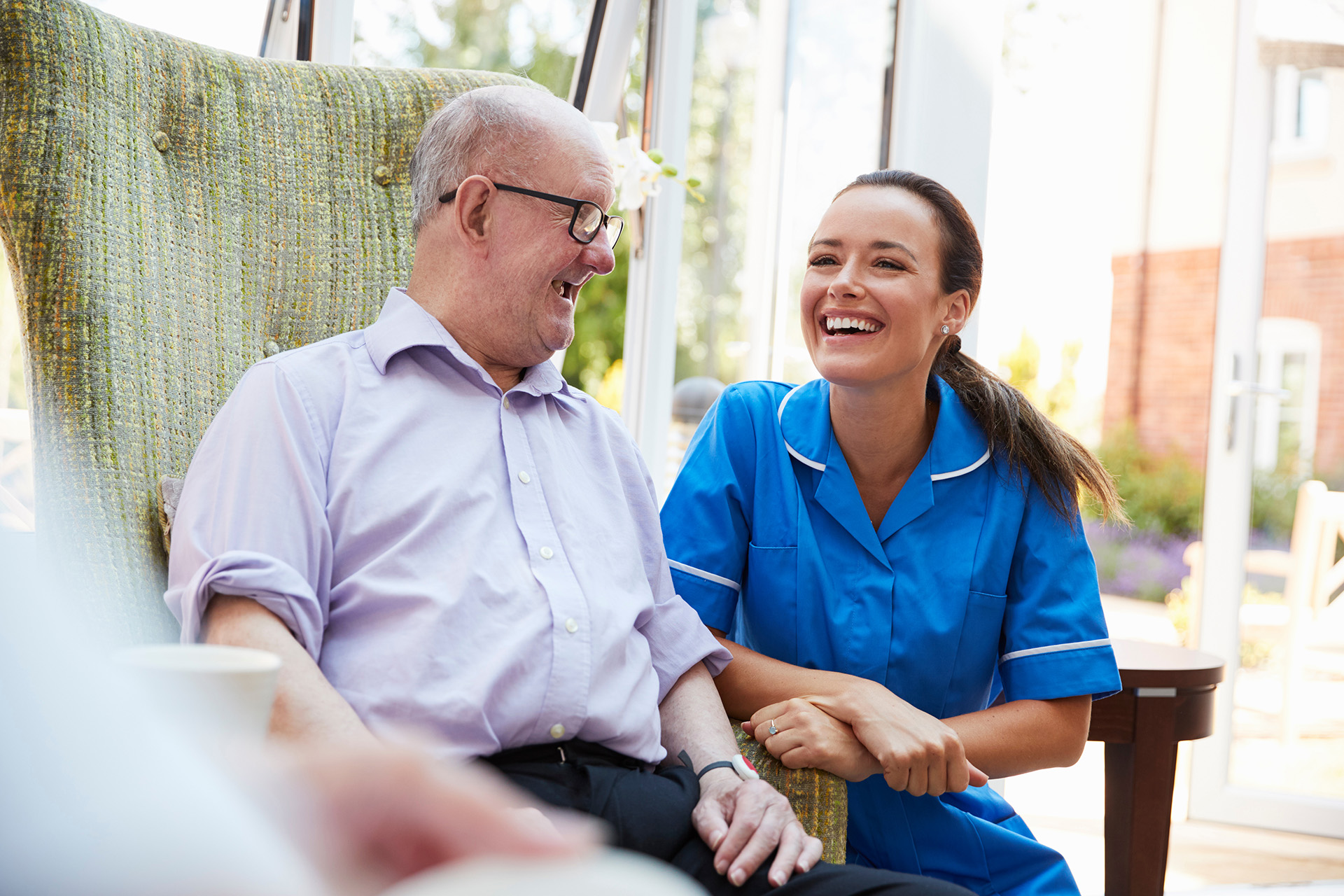 An elderly veteran sat down with a care worker in a care homes for veterans.