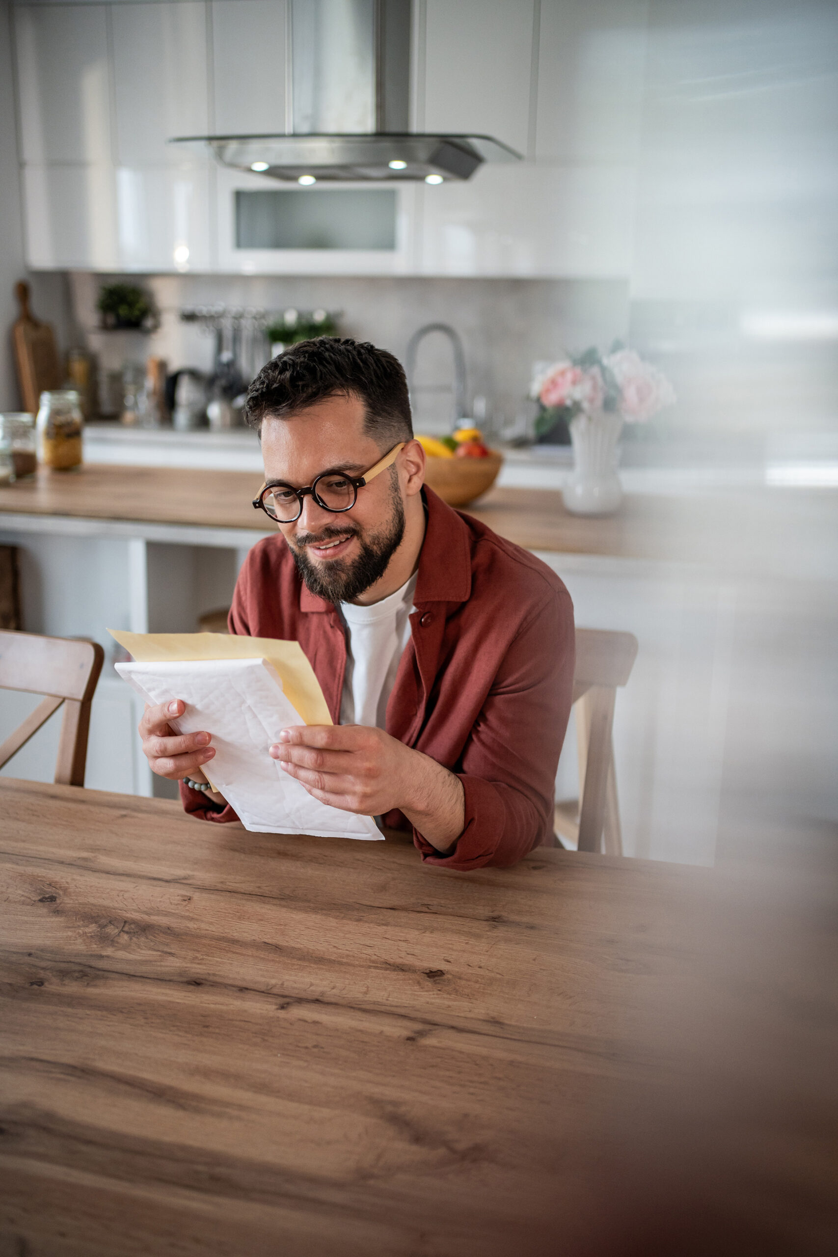 A veteran at a kitchen table looking at armed forces pensions advice.