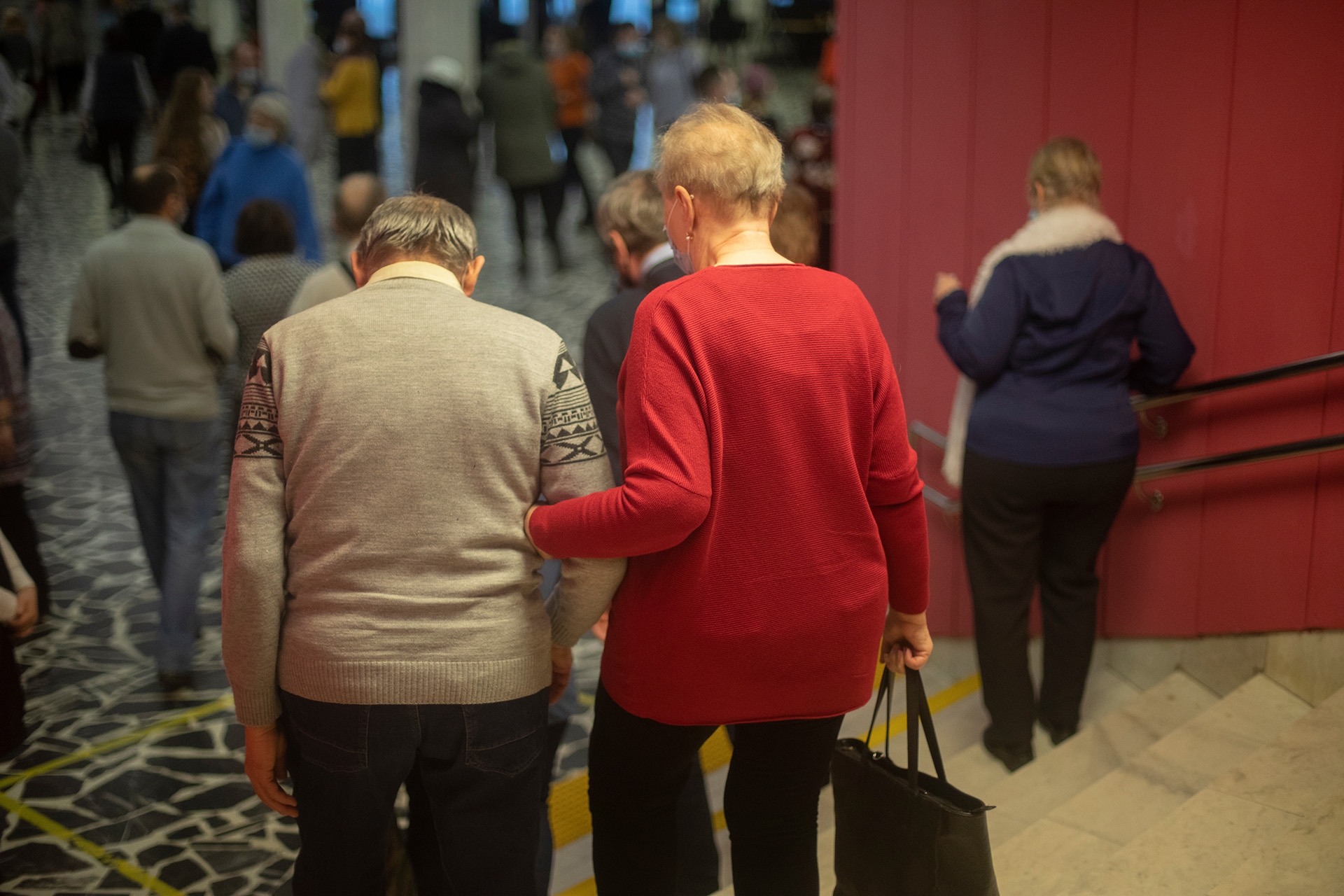 An elderly couple walking into a community space, highlighting community physical health support for veterans in Northern Ireland.