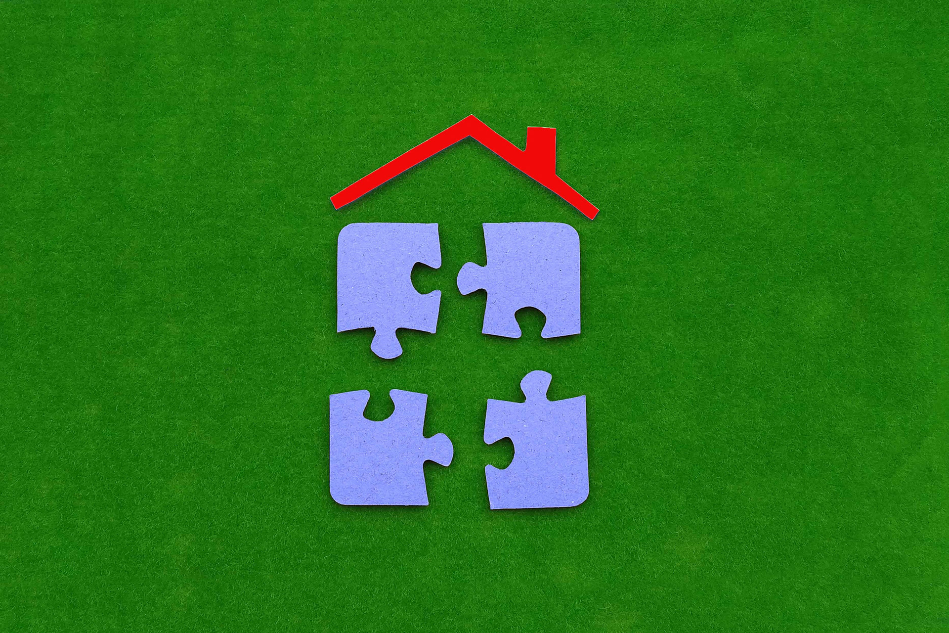 Puzzle pieces with a red roof on top, showing the concept of how the shared ownership scheme can help veterans with buying a house in Wales